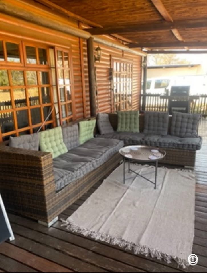 Covered wooden stoep with outdoor sectional seating at Acacia Lodge